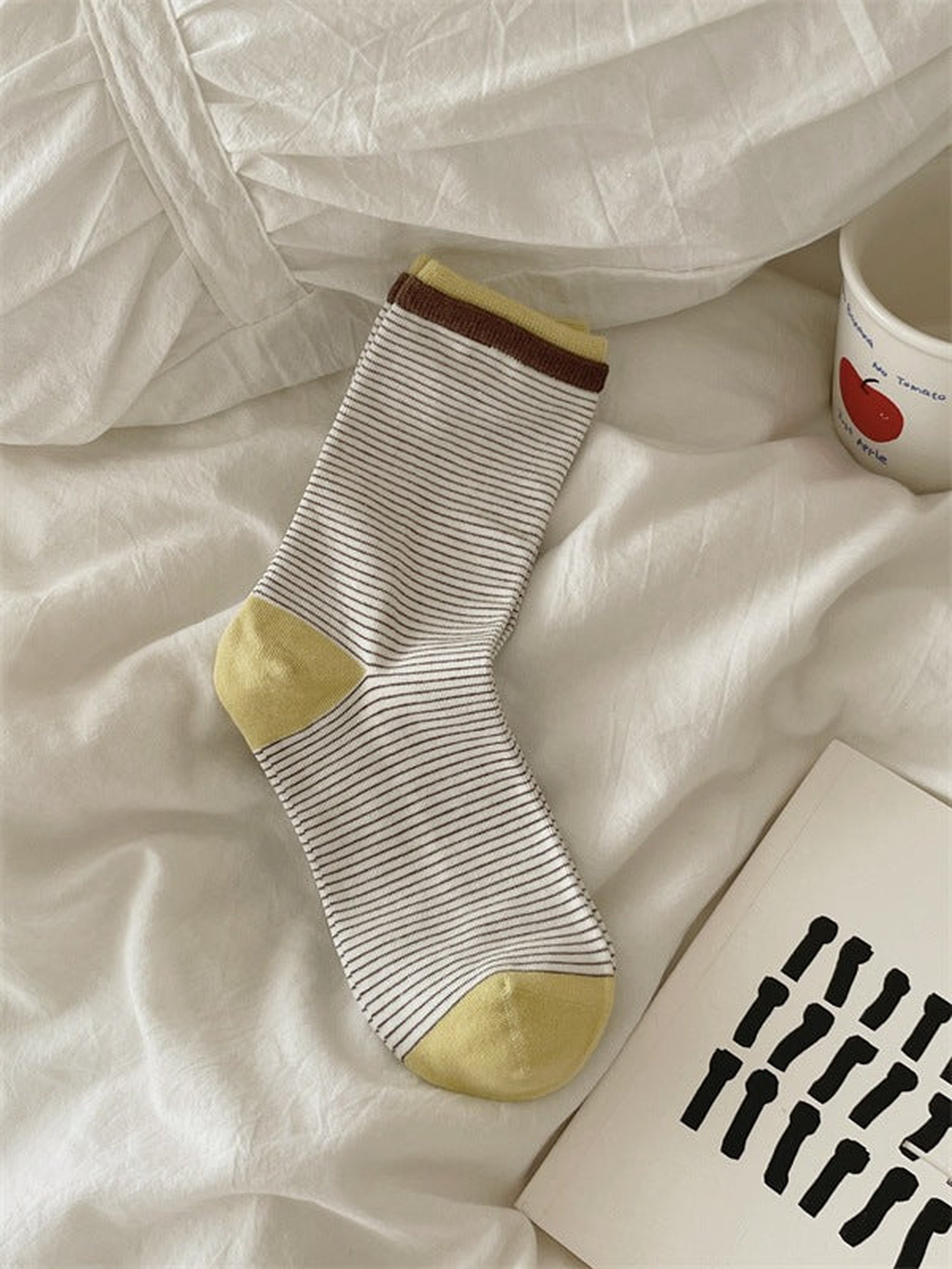 Ivory striped crew sock with brown and yellow cuff bands and yellow heel and toe, laid flat.