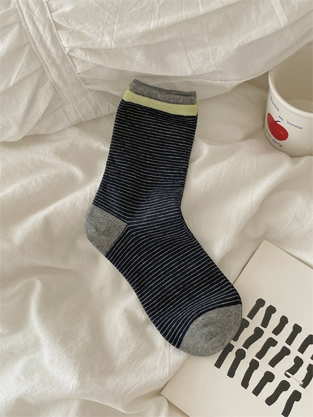 Black striped crew sock with yellow and gray cuff bands and gray heel and toe, laid flat.