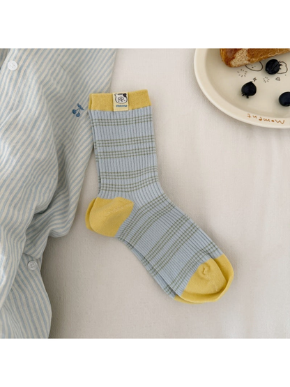 Blue / Yellow striped ribbed socks laid flat with contrasting cuff, heel and toe panels and a cat label.