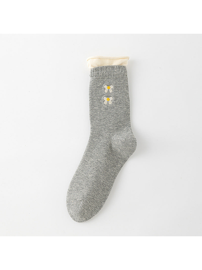Heather Gray crew sock with a cream rolled upper edge and white bow motifs with yellow centers.