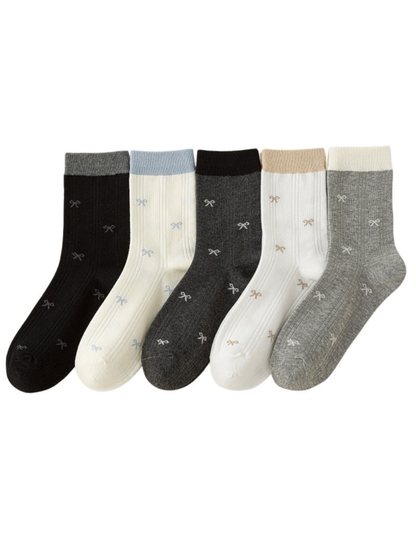 Bow-pattern crew socks in black, ivory, dark gray, white and light gray with contrasting cuffs.
