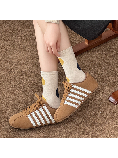 Beige socks with mustard and navy dots worn with tan lace-up shoes.