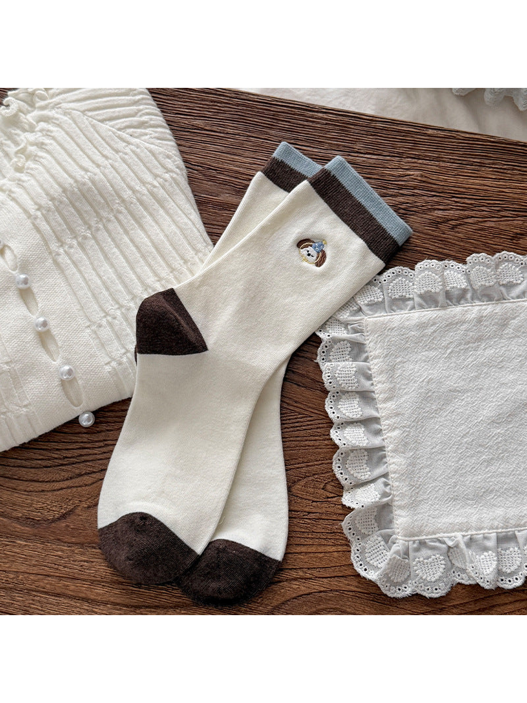Ivory crew socks with dog faces, brown heels and toes, and blue-edged cuffs