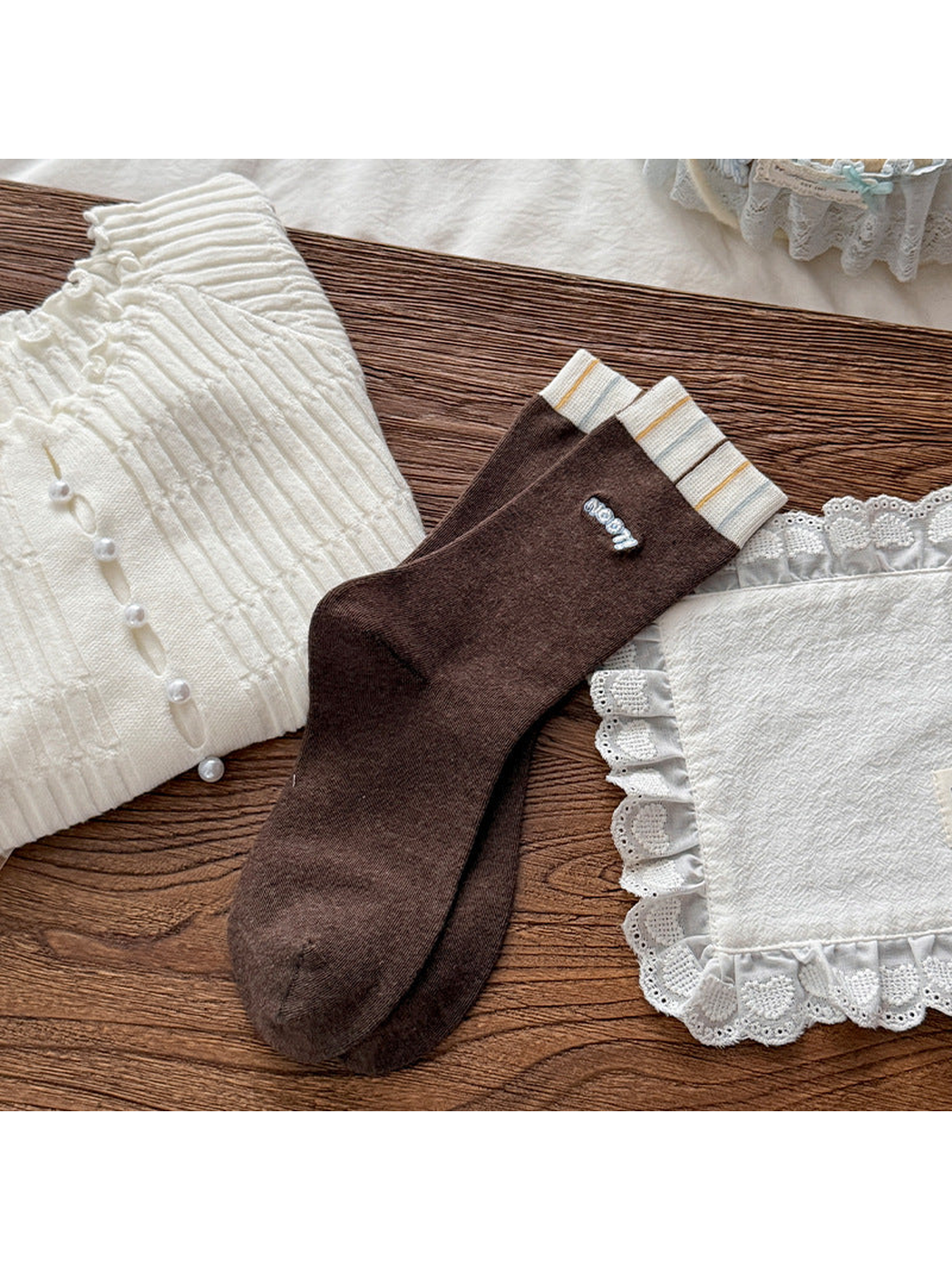 Dark Brown crew socks with striped ivory cuffs and small blue-and-white lettering