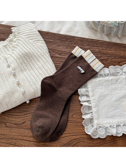 Dark Brown crew socks with striped ivory cuffs and small blue-and-white lettering