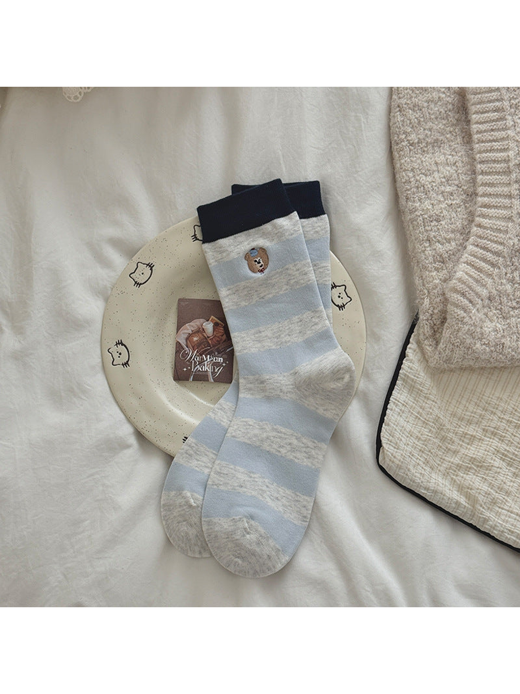 Light Blue striped socks with navy cuffs and embroidered bear motifs.