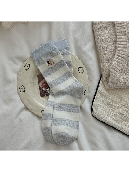 Gray Blue socks with pale blue cuffs, gray and ivory stripes, and embroidered cat motifs.