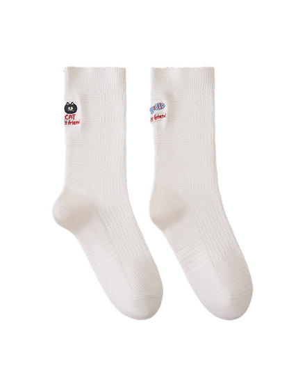 Ivory crew socks with cat and fish embroidery, ribbed cuffs, and geometric knit texture.