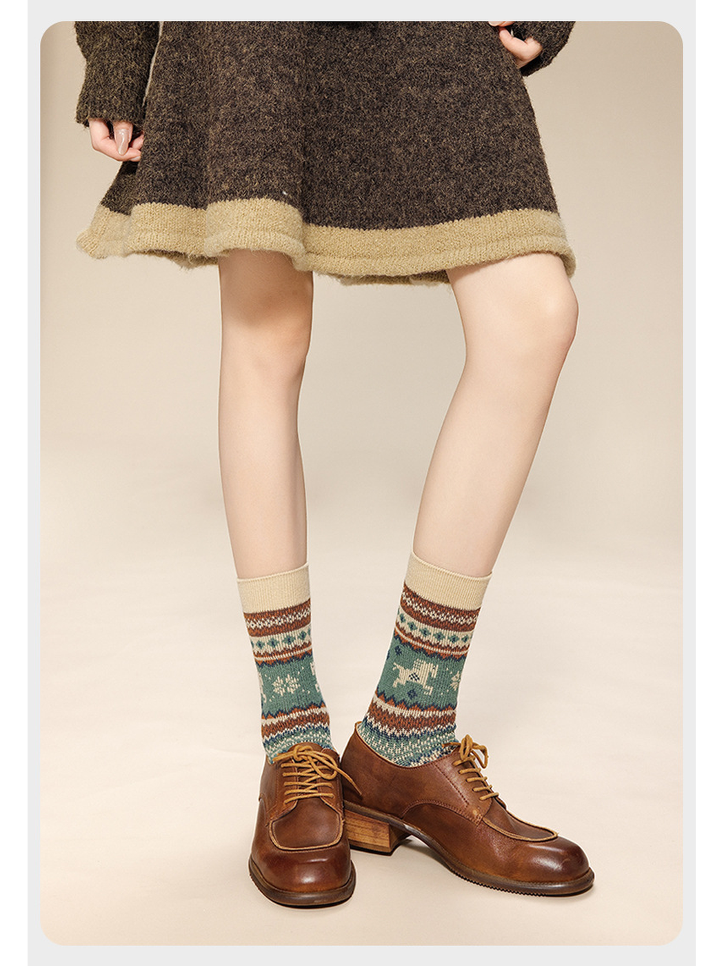 Cream horse-pattern crew socks worn with brown lace-up shoes and a knit skirt, viewed from the front.