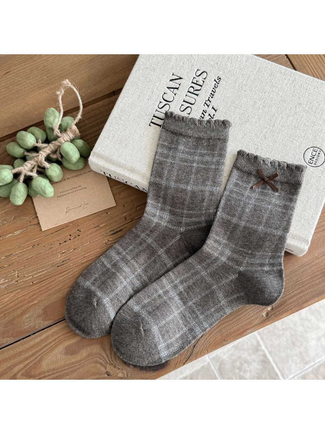 Plaid socks in heather gray with fine check lines and a brown cuff bow.