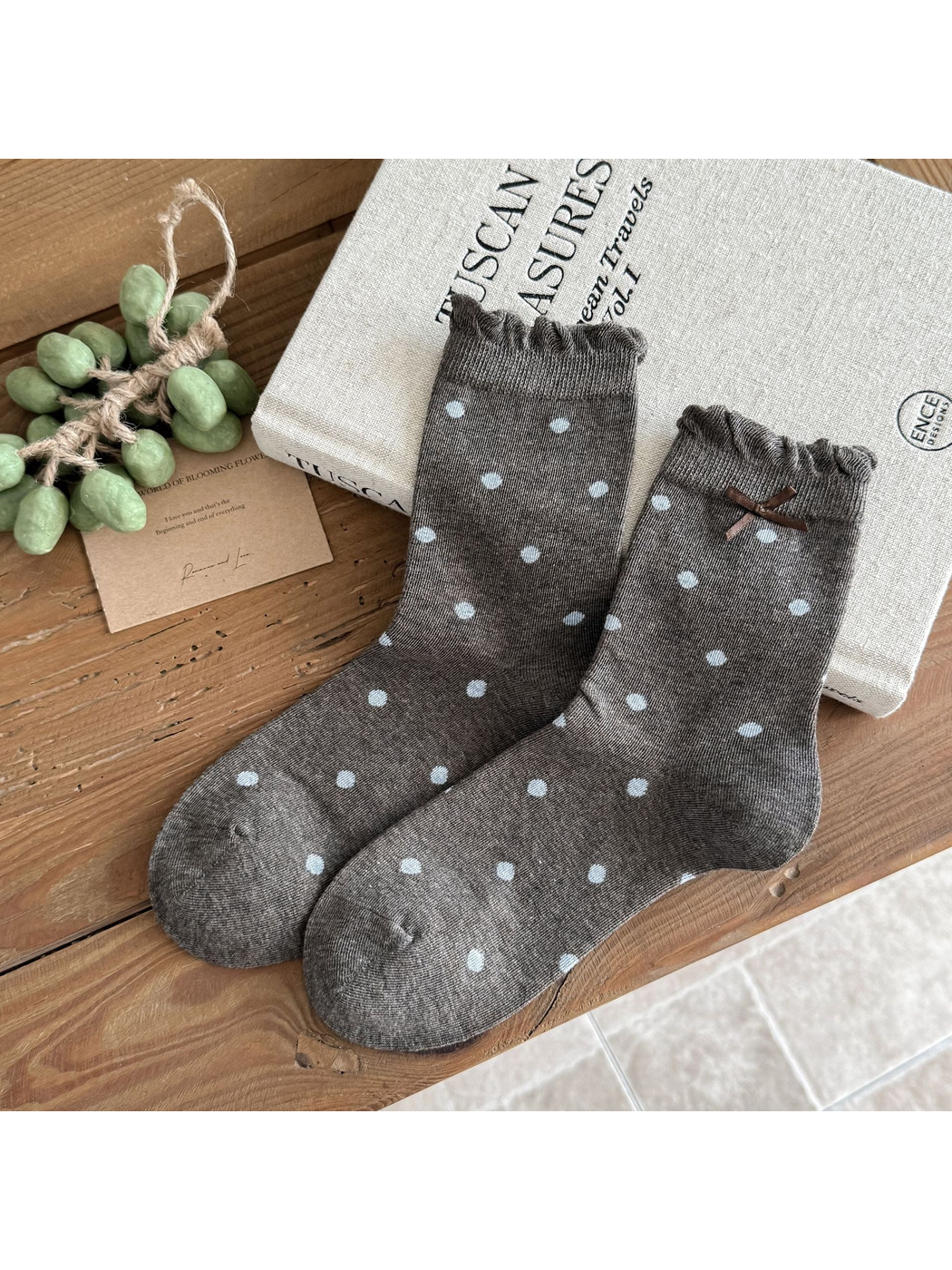 Large Dots socks in dark gray with light blue dots, ruffled cuffs, and a brown bow.