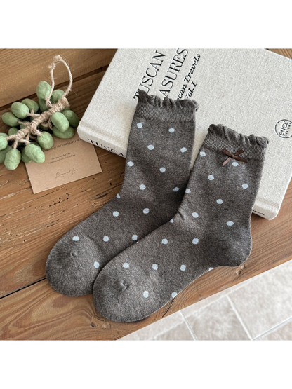 Large Dots socks in dark gray with light blue dots, ruffled cuffs, and a brown bow.