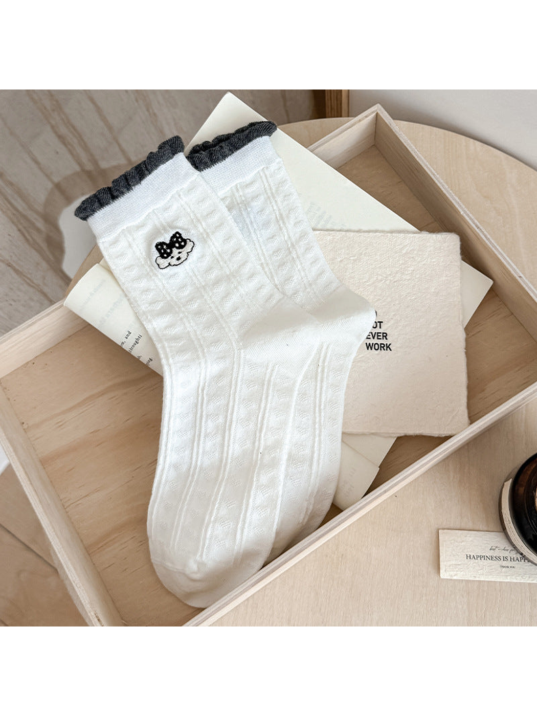 White Cartoon Face socks with vertical pointelle texture and dark gray ruffled cuff edges.