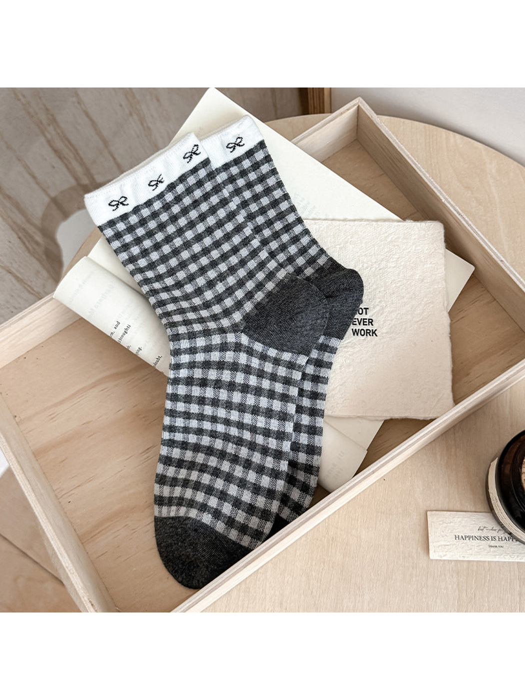 Gingham socks with gray and white checks, small cuff bows, and dark heel and toe panels.