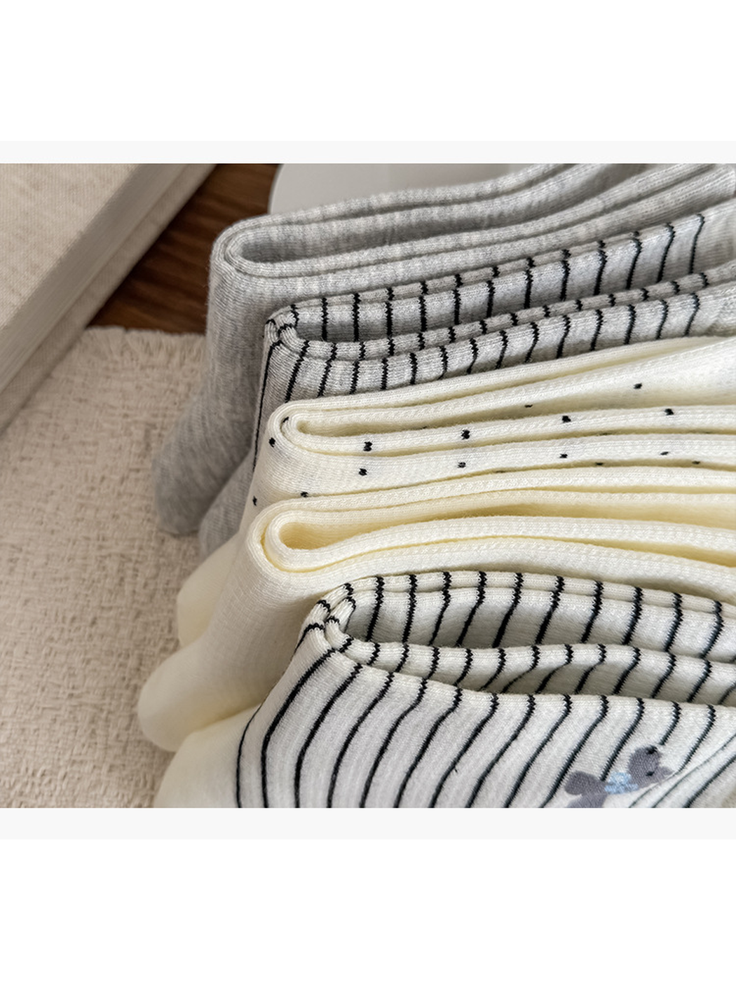 Close-up of folded sock edges showing knit texture, stripes, and dots.