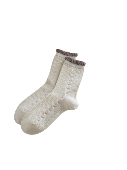 Heart style crew socks with raised hearts, vertical textured panels, and contrasting ruffled cuffs.