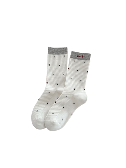 White Polka Dots socks with gray cuffs and cherry embroidery, laid flat.