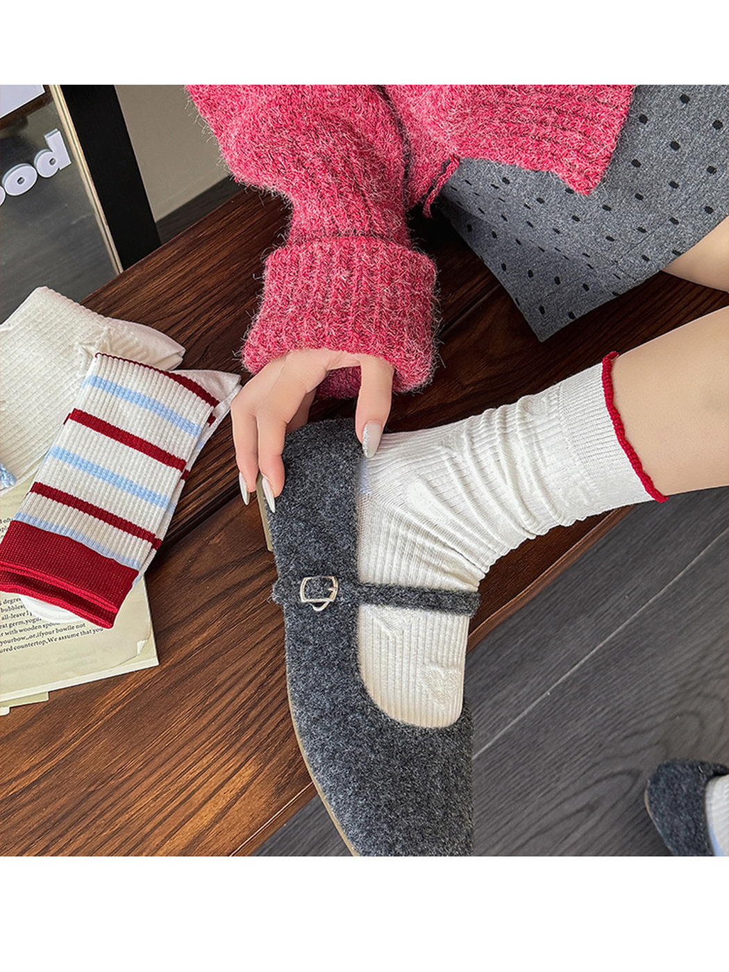 White heart-pattern socks with red cuff trim worn gathered above gray strap shoes, viewed from above