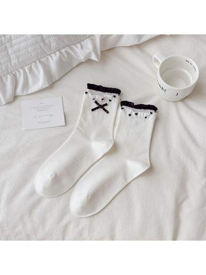 White Bow socks with black ribbon decoration and ruffled contrasting cuffs.
