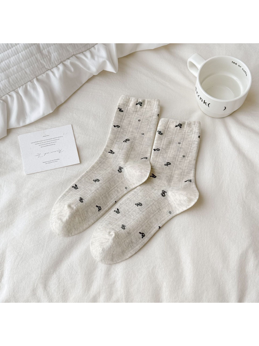 Light gray Floral socks with small dark motifs scattered across the surface.