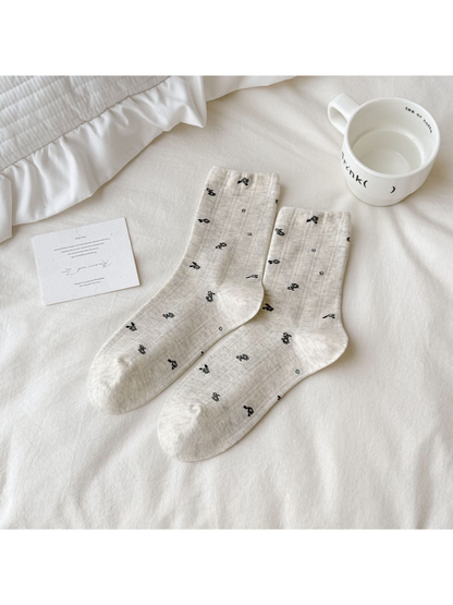 Light gray Floral socks with small dark motifs scattered across the surface.