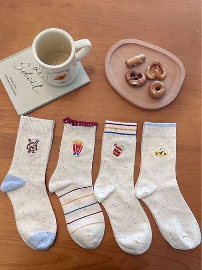 Ivory speckled socks laid flat in Dessert, Fries, Cup, and Chef styles, showing contrasting cuffs, heels, and toes.