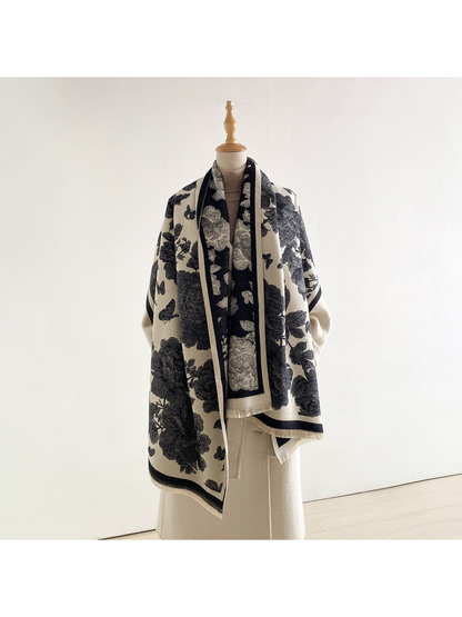 Black and cream floral scarf wrapped across a mannequin's shoulders with the cream side facing outward.