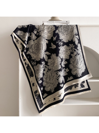 Black scarf draped to show cream flowers and butterflies, contrasting borders, and short fringe.