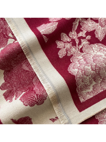 Close-up of the Burgundy scarf's short cream fringe and floral pattern beside the border.