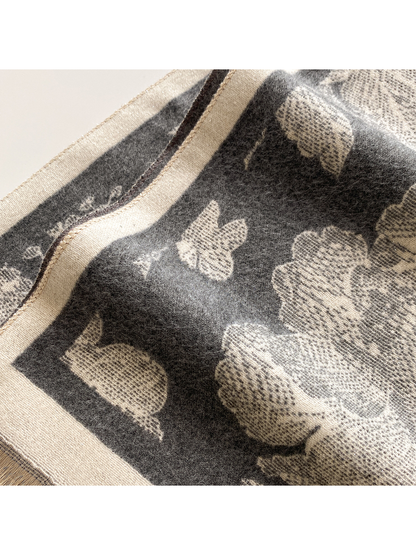 Close-up of the Dark Gray scarf's brushed surface, cream butterfly motif, and bordered corner.