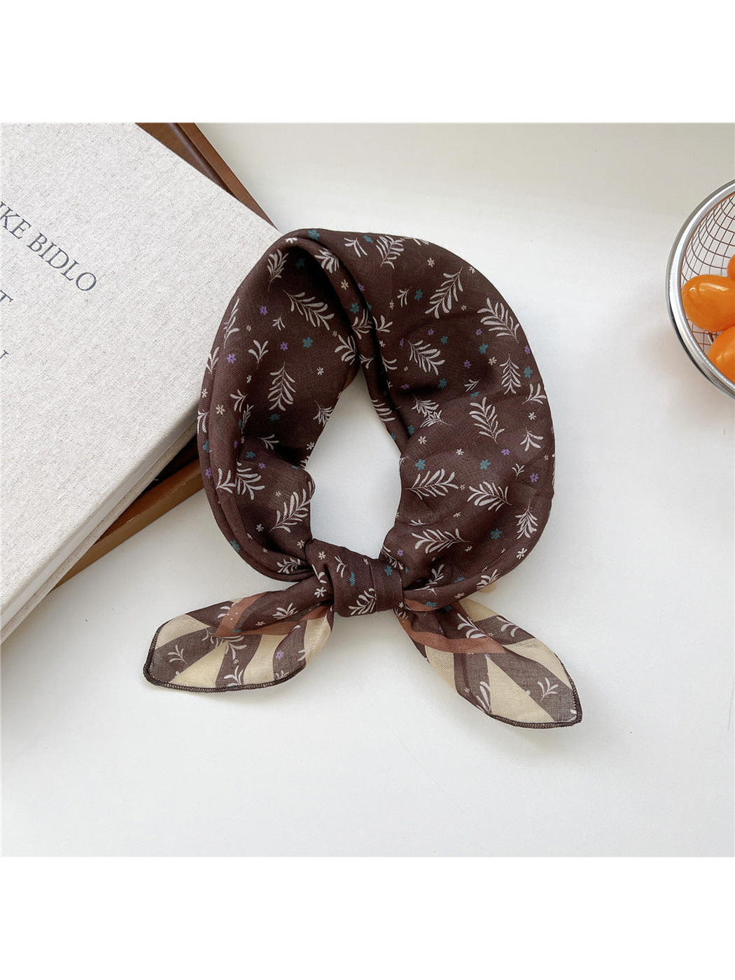 Coffee Sprigs scarf tied in a loop with small leafy sprigs and striped ends.