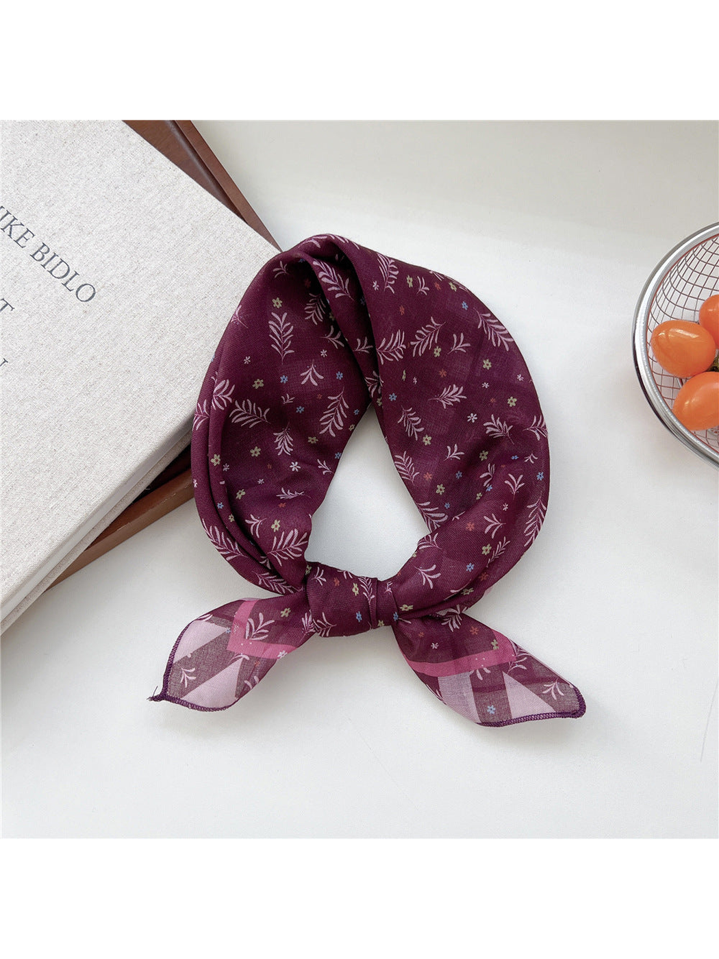 Burgundy Sprigs scarf tied in a loop with tiny flowers and pink striped ends.