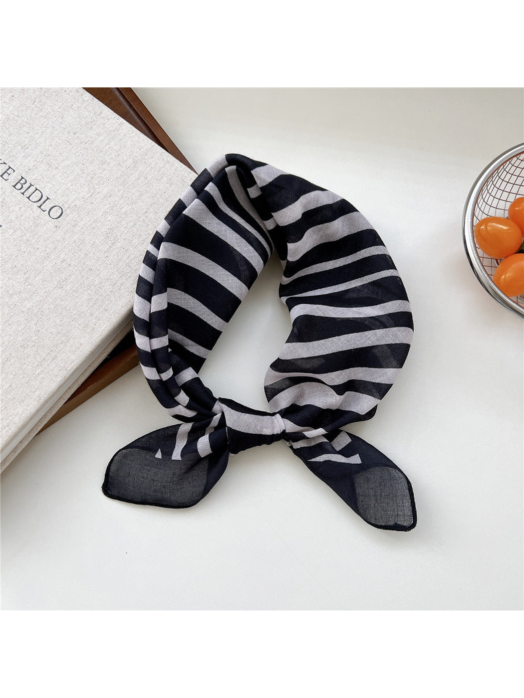 Black Zebra scarf tied in a loop with irregular white stripes.