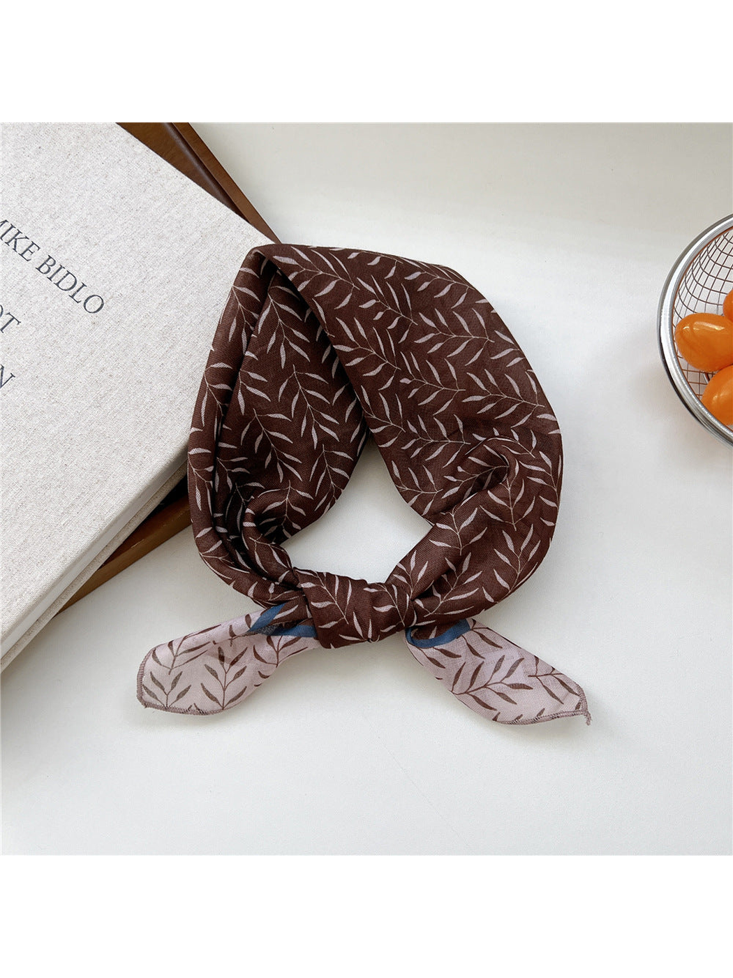 Brown Bamboo scarf tied in a loop with slender pale leaves and contrasting ends.