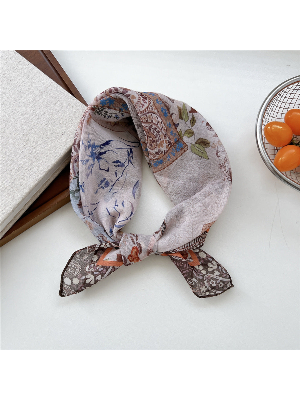 Greige Paisley scarf tied in a loop with floral panels and dark patterned ends.