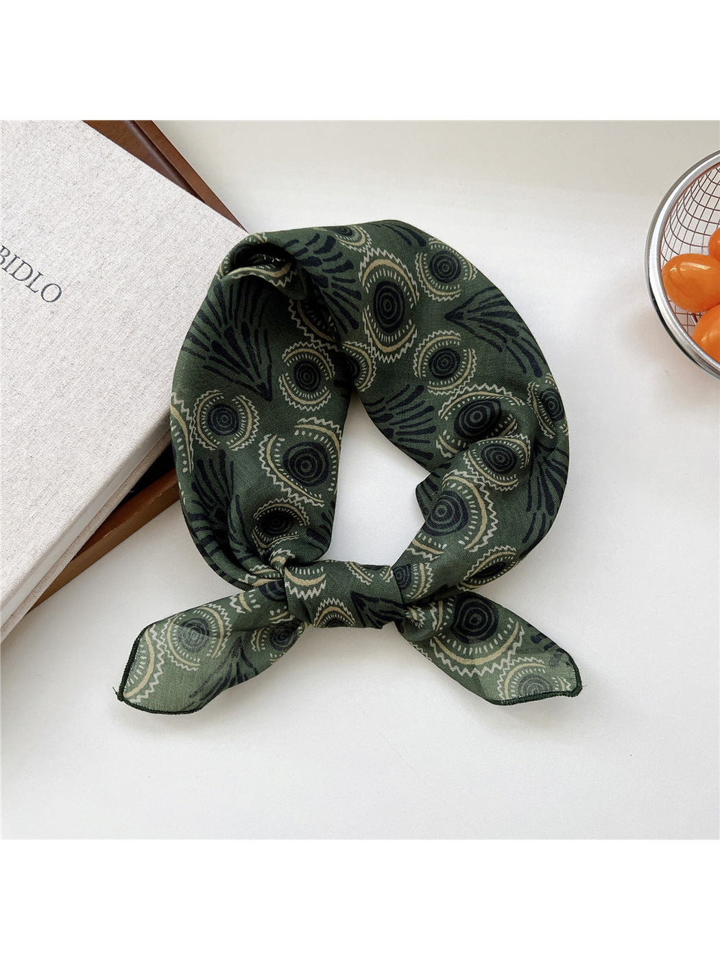 Green Circles scarf tied in a loop with concentric circles and fan-shaped motifs.