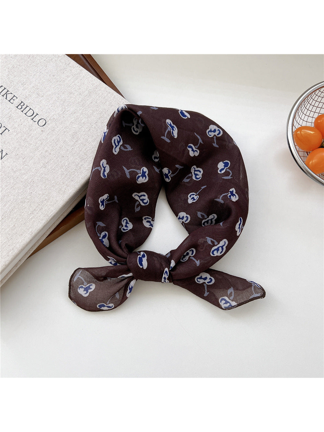 Coffee Shapes scarf tied in a loop with scattered blue-and-white motifs.