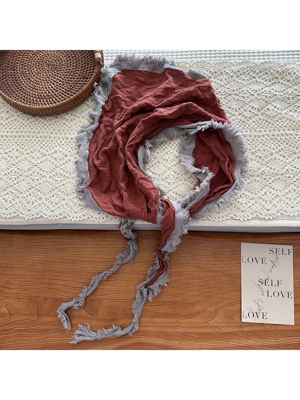 Orange Red scarf arranged in a loose loop with gray frayed trim and extended tapered ends.