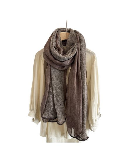 Coffee scarf with openwork and sheer panels draped in a long loop over a cream shirt.