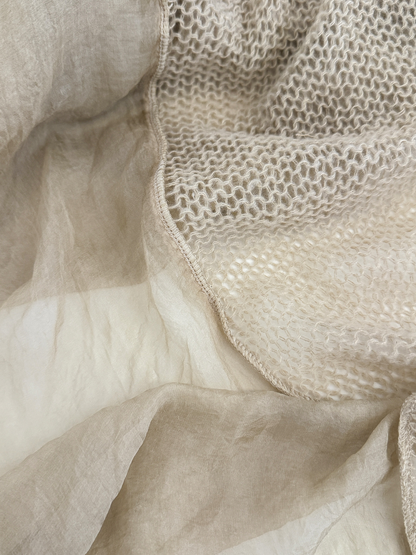 Close-up of the scarf's openwork panel, sheer panel and stitched joining edge.