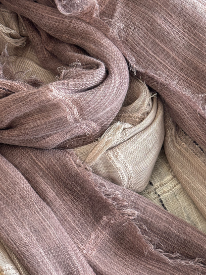 Close-up of layered scarves showing open weave, narrow openwork bands and frayed edges.