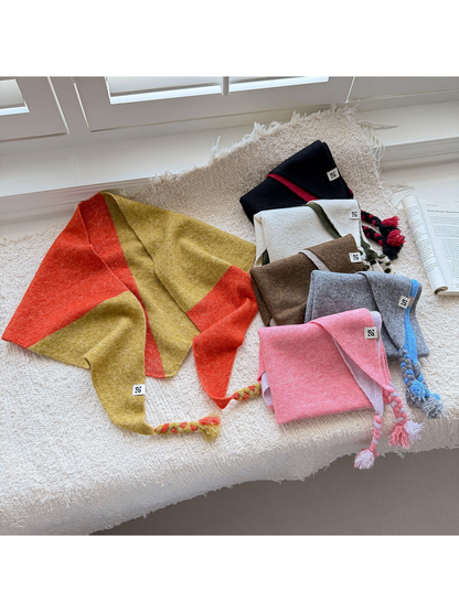 Six color block triangle scarves arranged together with braided tassel ends