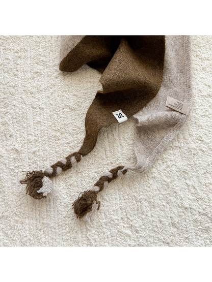 Close-up of the Coffee scarf's knit texture and two-tone braided tassels