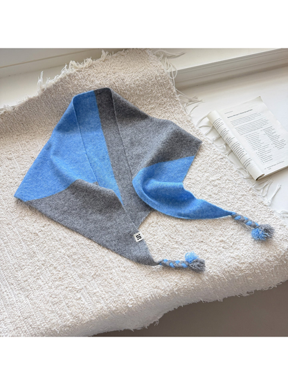 Gray Blue color block triangle scarf with braided tassel ends spread across a textured surface