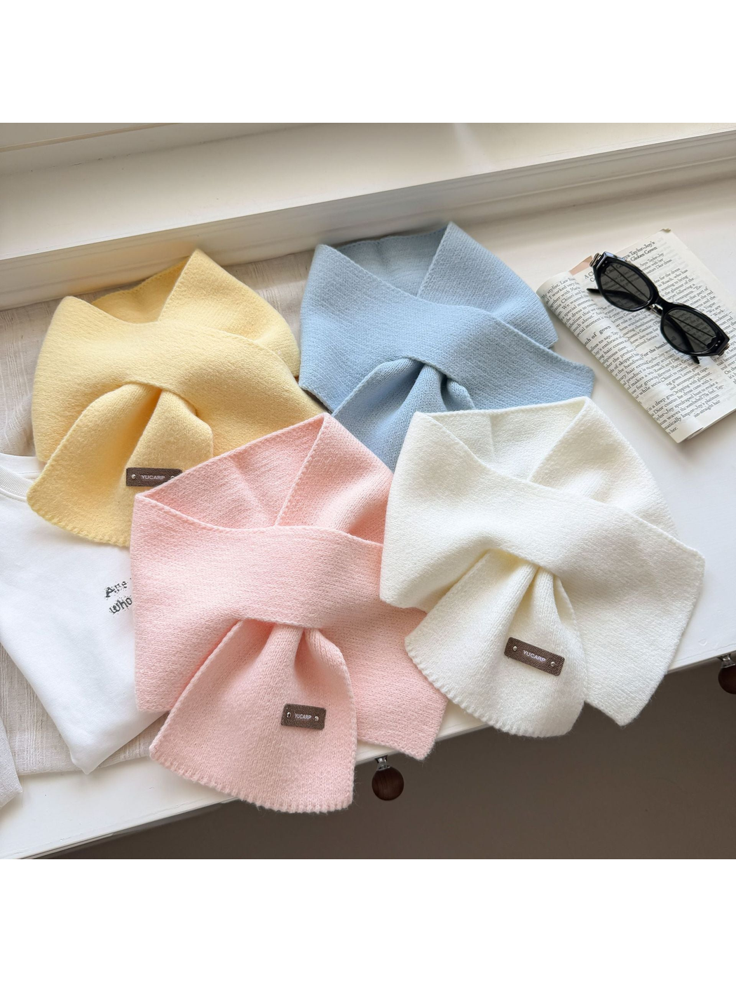 Yellow, Light Blue, Light Pink and Ivory knit scarves arranged in overlapping loops.