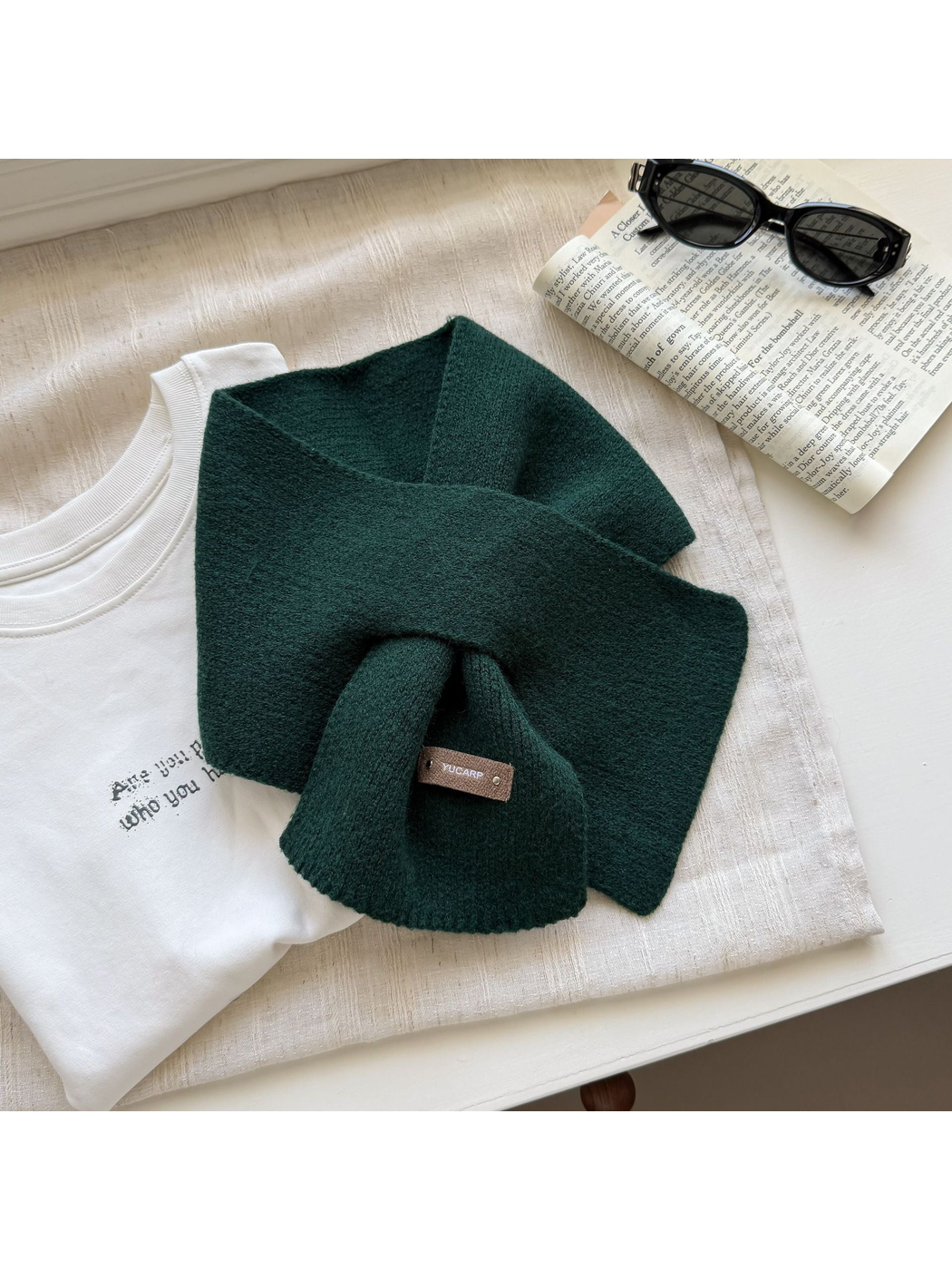 Dark Green knit pull-through scarf with a rectangular label near one end.