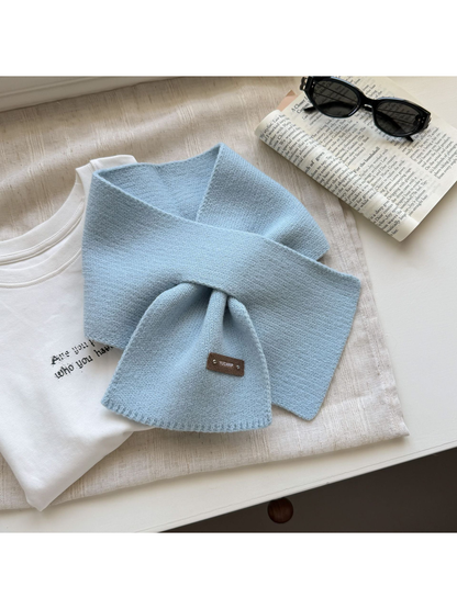 Light Blue knit pull-through scarf with a rectangular label near one end.