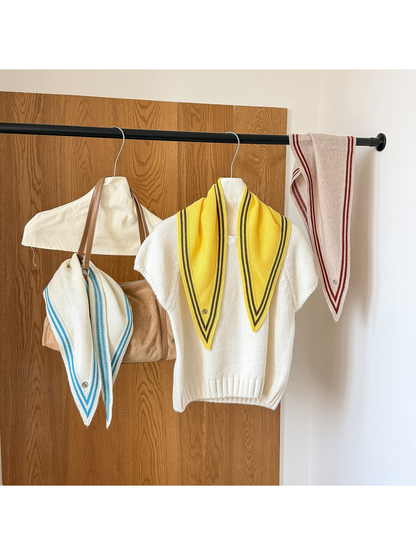 Yellow triangle scarf draped over a white top, with Ivory and Beige scarves displayed beside it.