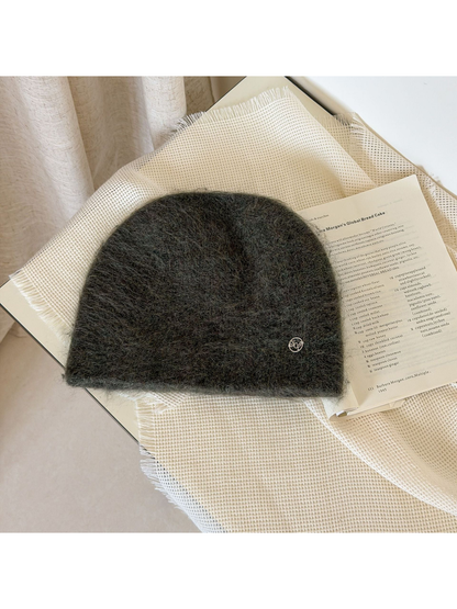 Army Green fuzzy knit beanie with a rounded crown and small silver-tone emblem.