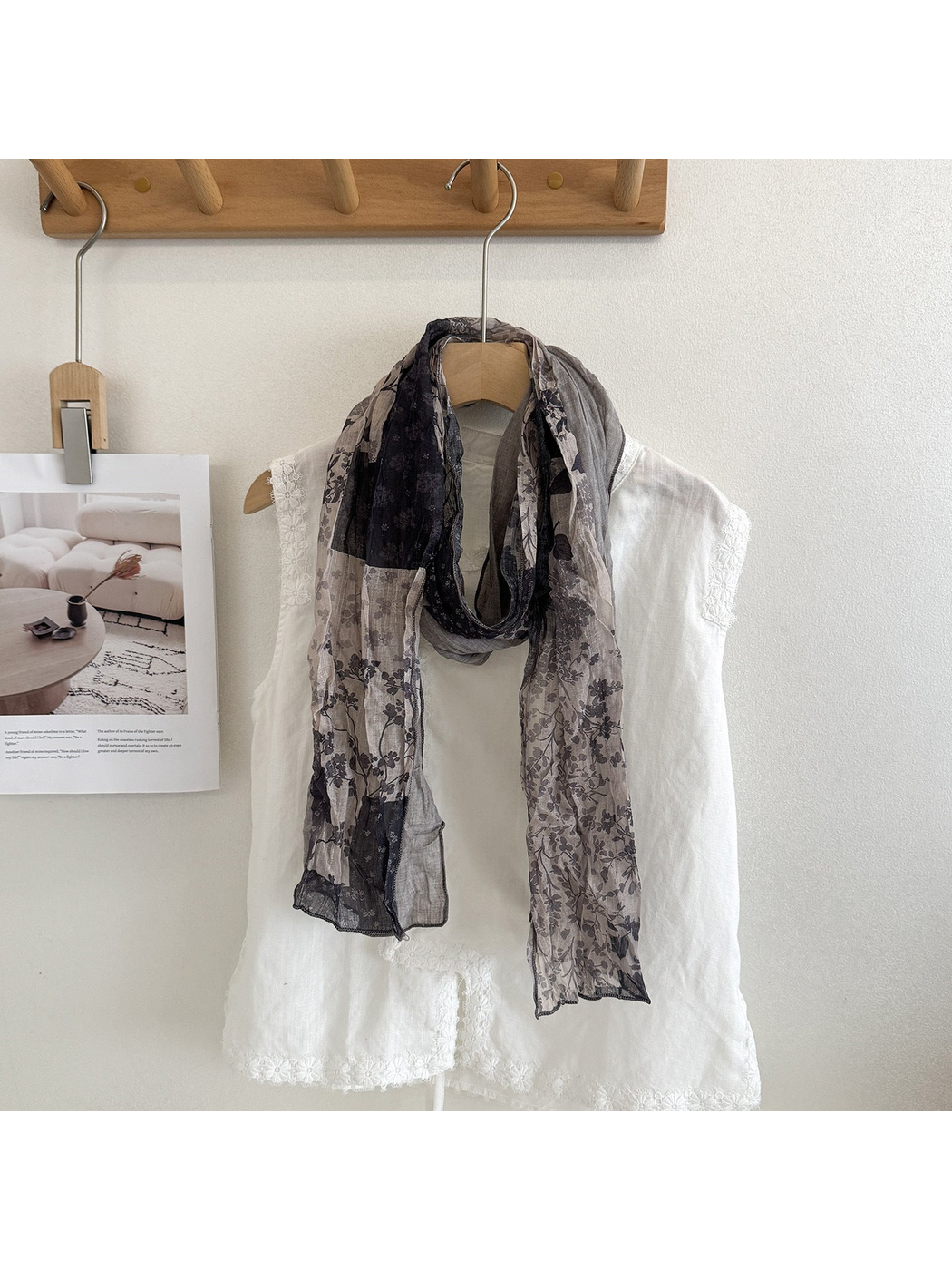 Gray floral patchwork scarf looped over a white top.